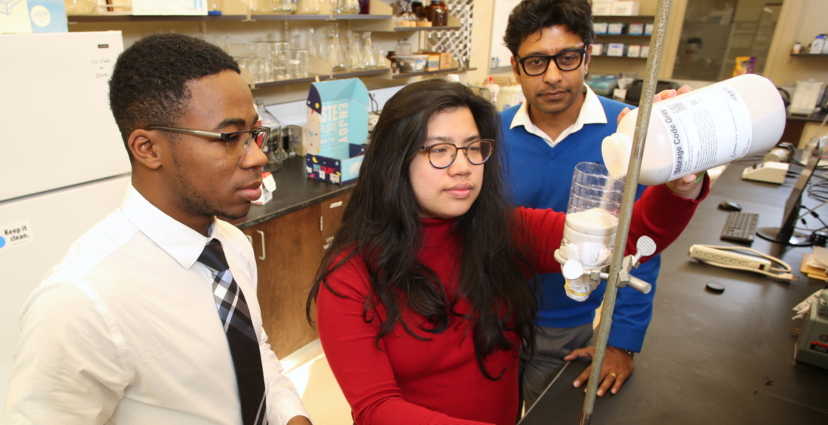 University of South Alabama engineering students Bryant Baldwin, left, and Rachel Chai, center, are creating a filter to adsorb, or adhere, phosphate from wastewater and/or stormwater, under the guidance of Dr. Arka Pandit, an assistant professor of civil, coastal and environmental engineering at USA.