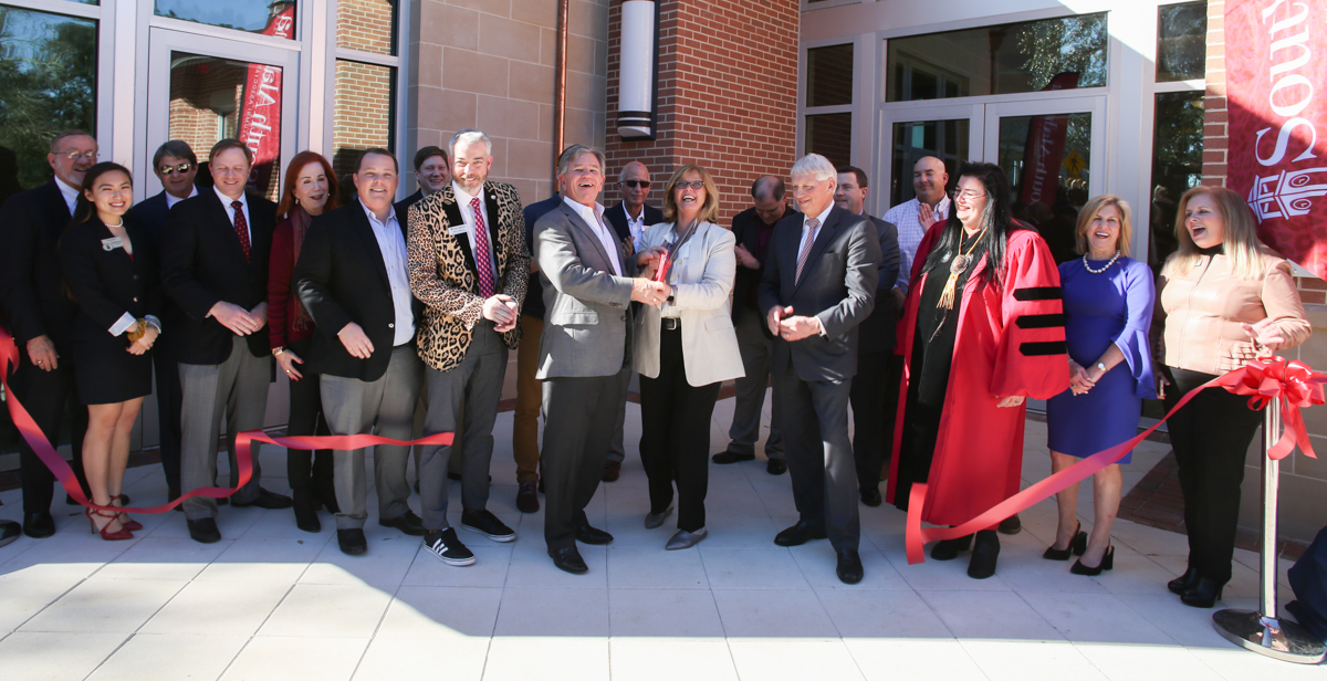 Julian and Kim MacQeen, center, join South alumni and supporters to cut the ribbon on the MacQueen Alumni Center. The 15,000-square foot-facility is in the center of campus, across from Moulton Tower and Alumni Plaza.