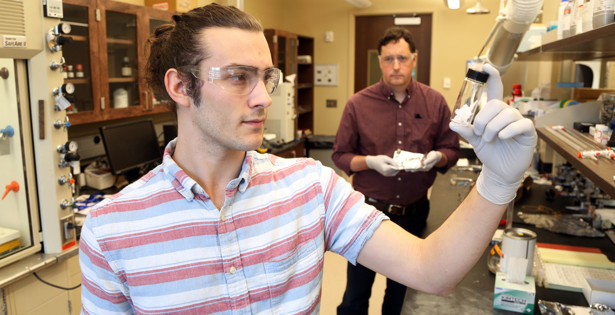 Joe Milter, who graduated in May from the University of South Alabama, works with Dr. Kevin West, background, professor of chemical engineering, in a College of Engineering lab during spring semester. Milter is one of the students who has worked on an antimicrobial fiber research project, collaborated on by West and Drs. Grant Glover, associate professor of chemical engineering, and Terry Ravine, associate professor of biomedical sciences.