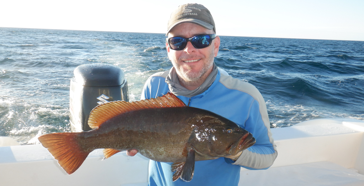 Dr. Ronnie Baker, an assistant professor of marine science at the University of South Alabama, holds a grouper off San Cristobal Island in the Galapagos. When he returns for research, Baker plans aims to identify coastal nursery habitats for fisheries species.