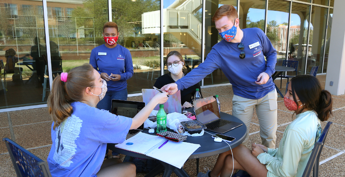 Grant Skinner and Sarai Garraway, both juniors and South Strong Ambassadors at the University of South Alabama, meet with fellow students recently outside the Student Center to talk about the importance of following precautions to keep people safe from COVID-19. 