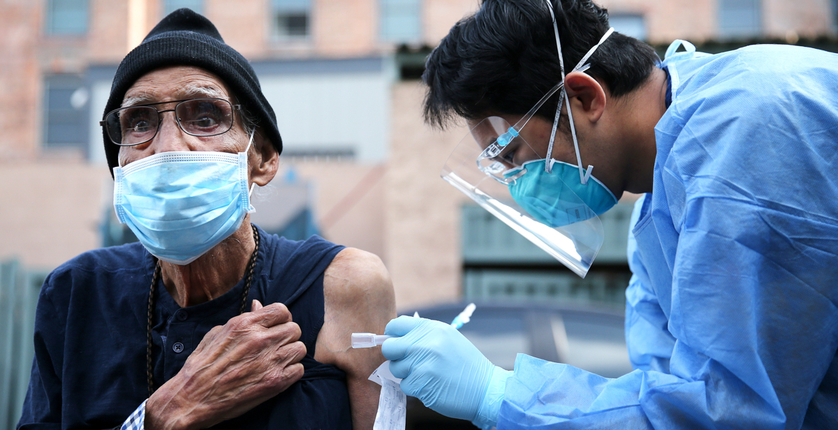 Angelo Bautista, a 2009 graduate of the University of South Alabama College of Nursing, gives a COVID-19 vaccine earlier this year in the Skid Row community of Los Angles. Skid Row is home to thousands of people who either live on the streets or in shelters for the homeless. Photo by Mario Tama/Getty Images.