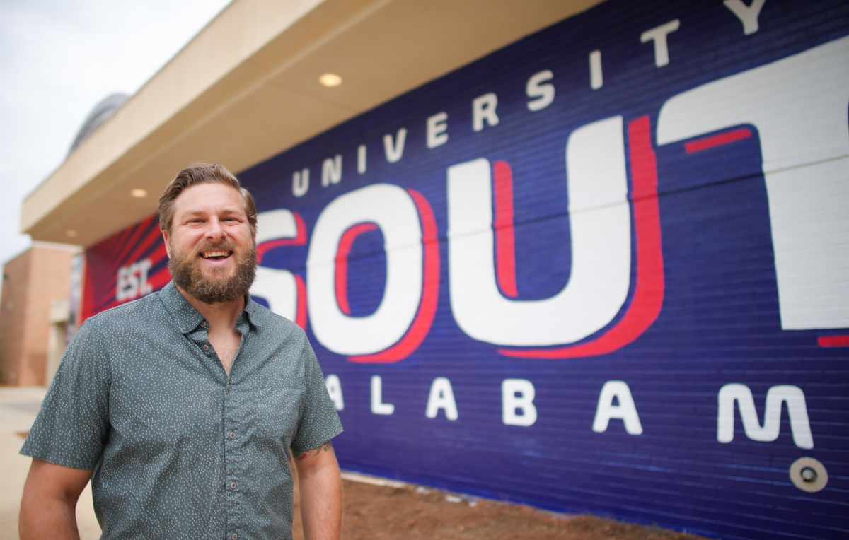 Muralist and University of South Alabama graduate Andy Scott's latest work is on the side of the USA Student Center — a bright mural in Pantone 281 and 193.