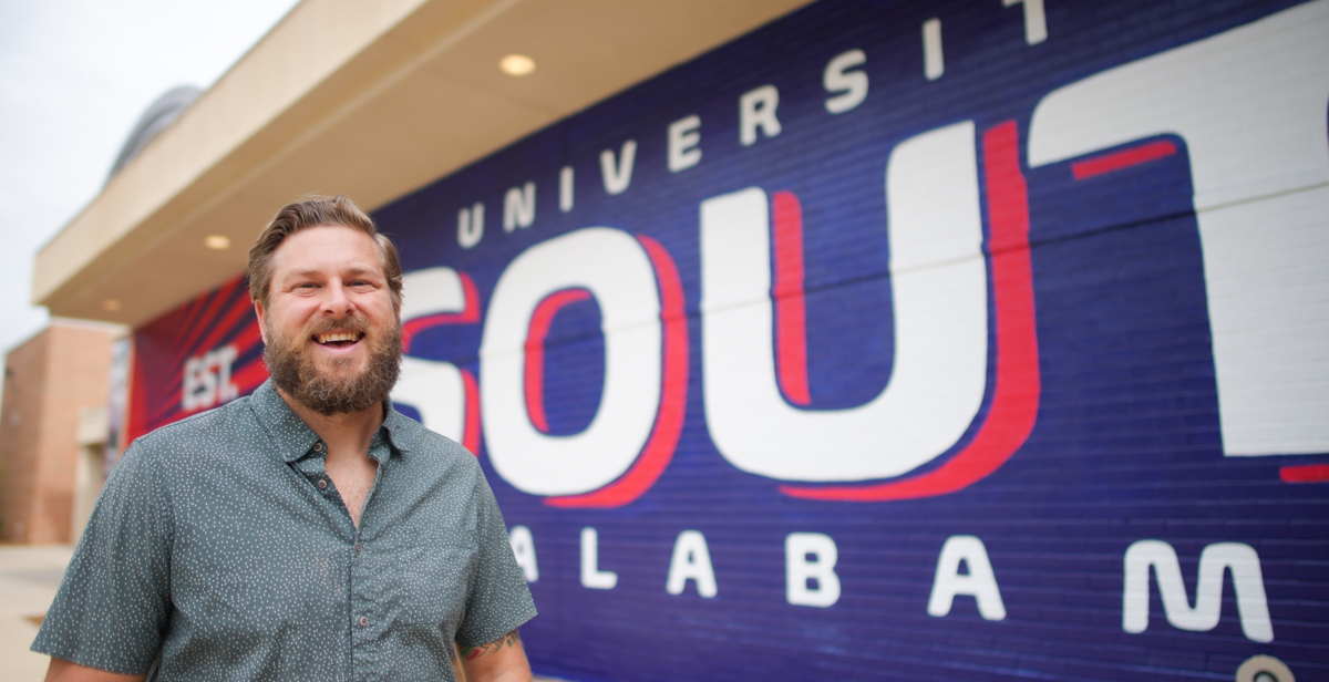 Muralist and University of South Alabama graduate Andy Scott's latest work is on the side of the USA Student Center — a bright mural in Pantone 281 and 193.