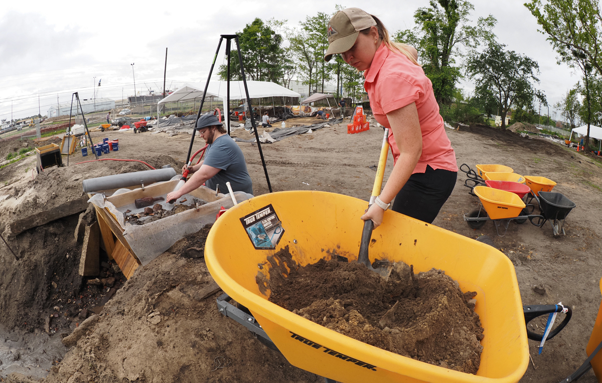 Erin Lister, a South anthropology student, transfers soil excavated from a colonial feature into a water screen for processing.