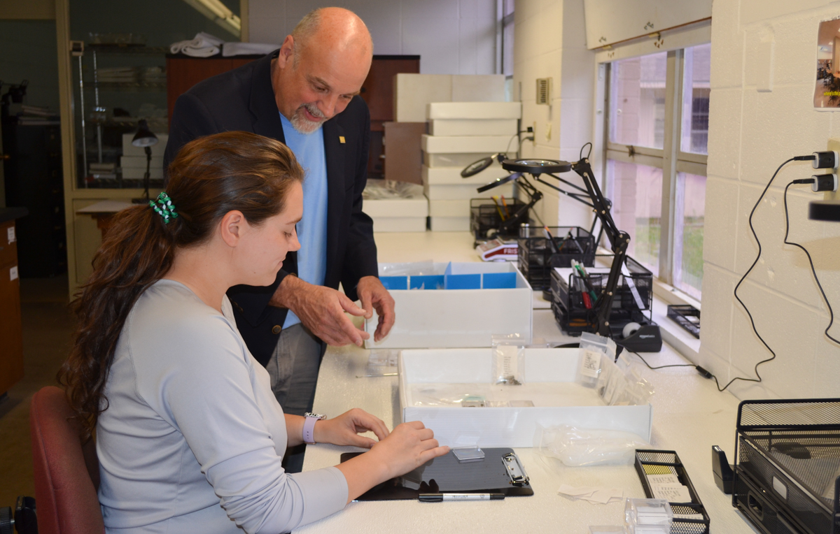 Alisha Palmer, a senior majoring in anthropology, and Dr. Phil Carr, professor of anthropology and the Chief Calvin McGhee Endowed Professor of Native American Studies, catalog artifacts brought in from the Mobile Bay bridge site in a lab at the USA Center for Archaeology Studies.