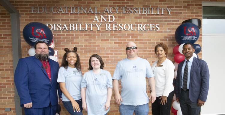 The University of South Alabama’s Division of Student Affairs gathered to dedicate its Center for Educational Accessibility and Disability Resources, which will serve more than 600 students with disabilities. From left are Eric Light, testing coordinator; Antionette Lett, senior student assistant; Jessica Hultquist, graduate assistant; Michael Evers, sensory impaired coordinator/USA alumnus, Greta Washington, secretary; and Mario Sheats, director of the center. data-lightbox='featured'