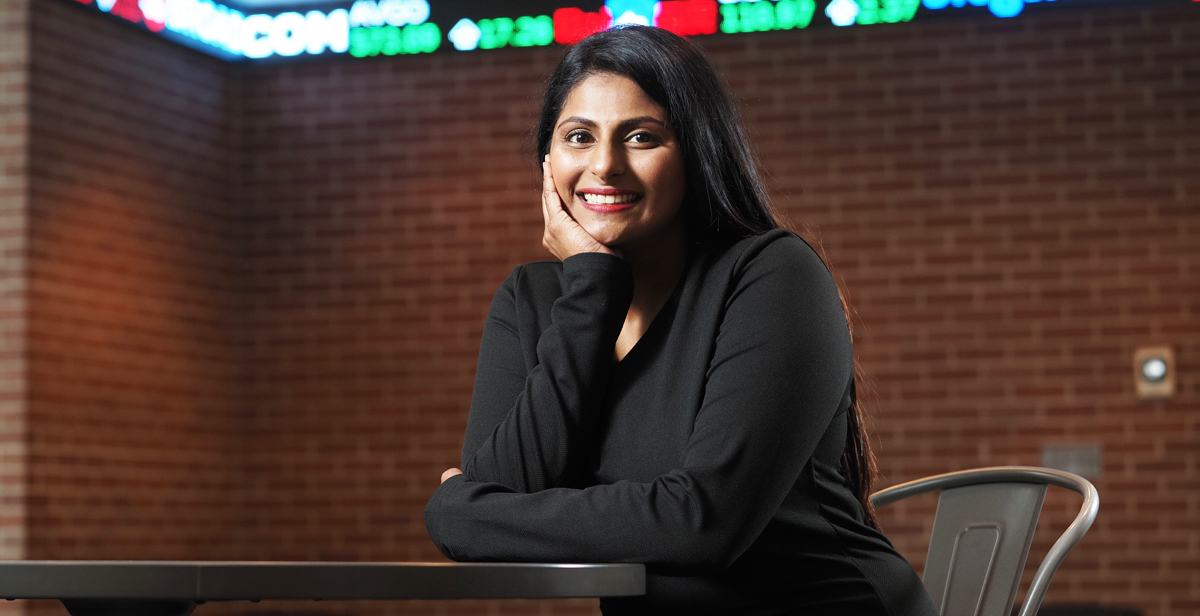 Snehal Adekar smiling sitting at table.