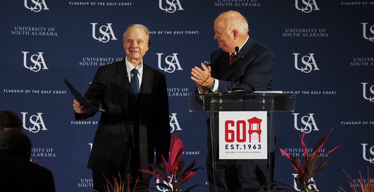 University of South Alabama President Jo Bonner, right, announces a $20 million gift from Abraham "Abe" Mitchell at the University's 60th Anniversary celebration. The donation will be used to build a new performing arts center on campus.  