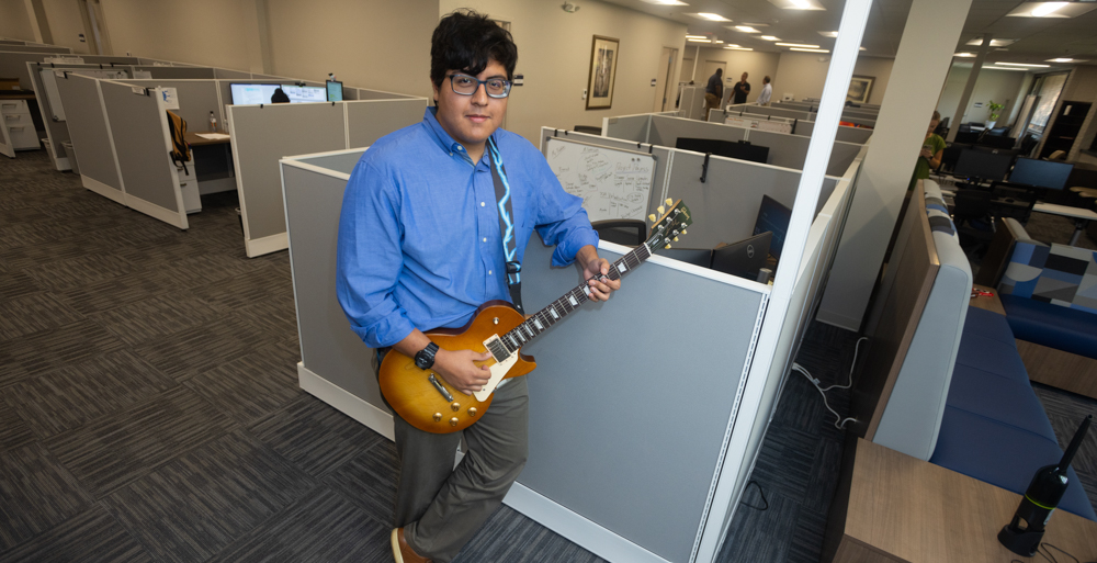 Diego Salas Polar in his office with his guitar.