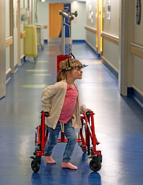 Abby Flowers navigates the halls of USA Health Children’s & Women’s Hospital with the help of a halo gravity traction-equipped custom walker. 