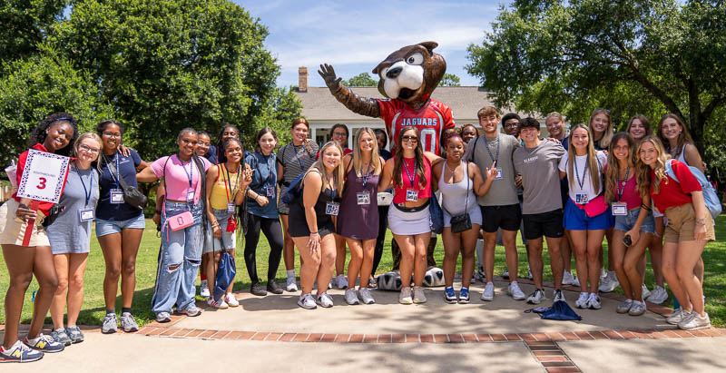 students taking a photo with SouthPaw statue