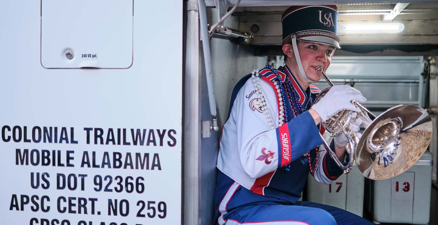 A band member practicing in the well of the bus