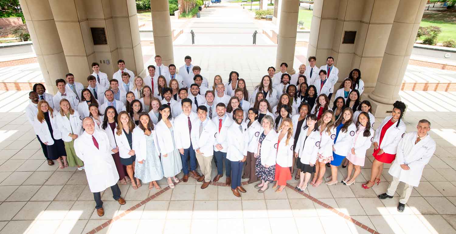 Group photo of the Whiddon College of Medicine Class of 2028 in their white coats.