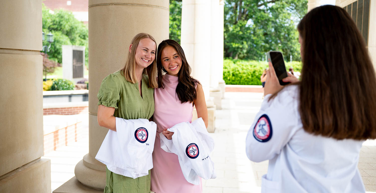 Third-year medical students taking a picture in their white coat.