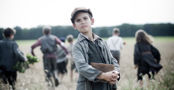 Boy facing camera as other children run away in the background representing "Run Boy Run",one of the featured films of the 2015 Mobile Jewish Film Festival at USA.