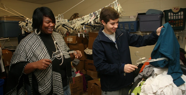 Bobbi Vaughn Kidd, food nutritionist at Dumas Wesley Community Center sorts clothing items with USA student Reed Morler, a pre-physical therapy major and presidential scholar.