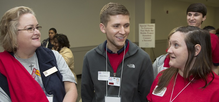 University faculty, staff and students assisted at the Project Homeless Connect event at The Grounds. Talking with two USA student volunteers is Karen Peterson, director of USA's Center for Academic Service-Learning and Civic Engagement.