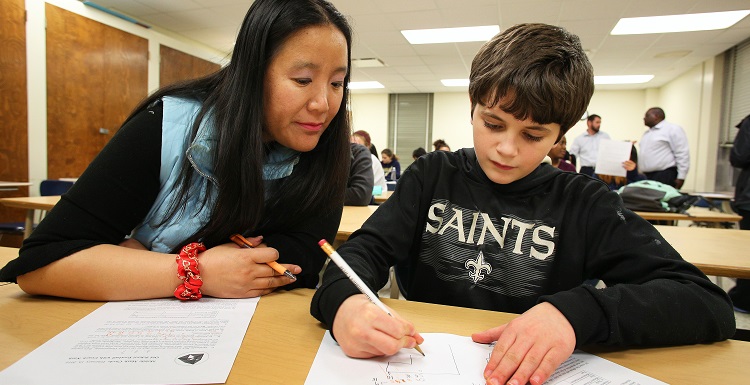 Min Zhu, a University of South Alabama student pursuing her master’s degree in math education, helps 8th-grader Ian Robertson of Mobile problem solve during a weekly Math Circle session at South.