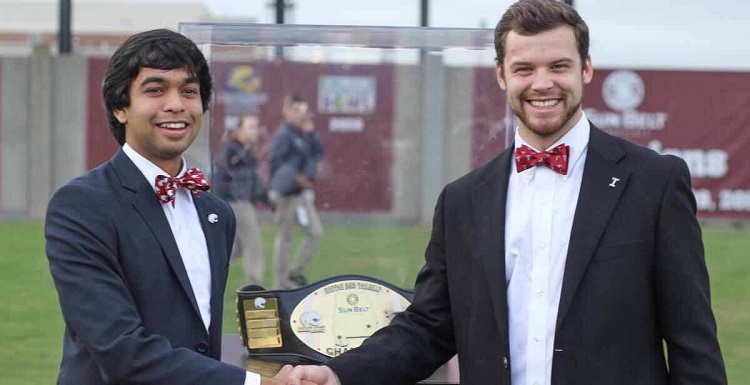 USA SGA President Ravi Rajendra is seen with Troy University SGA President Heath Barton as Rajendra prepares to present the “Battle for the Belt” trophy to the Jaguar football team.