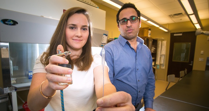 University of South Alabama graduate student Emily Turner holds a balloon catheter in a lab with her research mentor Dr. Saami Yazdani. 