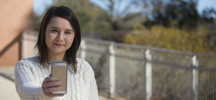 female facing camera and taking selfie with mobile phone 