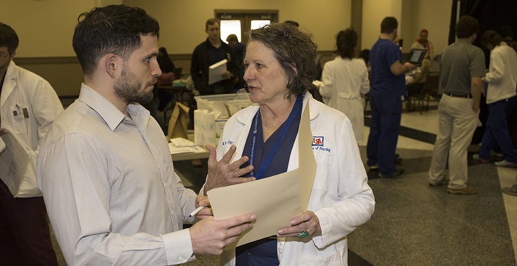 William Crittenden, a fourth-year College of Medicine student, discusses logistics at Project Homeless Connect with Dr. Margaret Moore-Nadler, chair of USA’s Health and Wellness Committee and associate professor of community mental health in the College of Nursing at South.