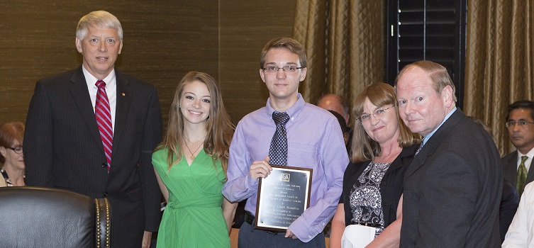 Jeffrey Hamilton, center, was recognized as the first Board of Trustees Scholar at the Board's Sept. 9 meeting. USA President Dr. Tony Waldrop, far left, and Trustee Chair Pro Tempore Dr. Steve Furr, far right, are pictured with Hamilton and members of his family.  