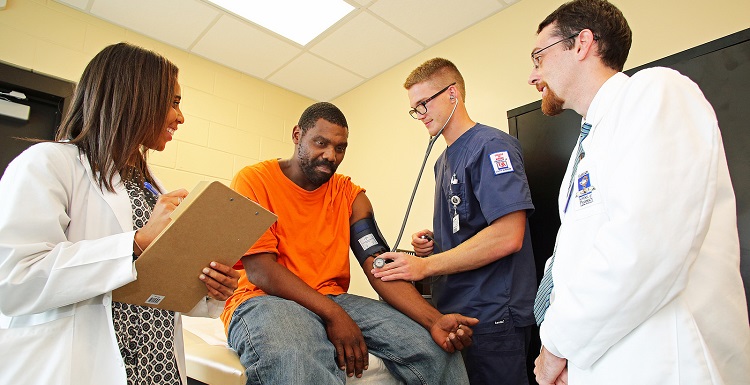 student physicians with patient in clinic