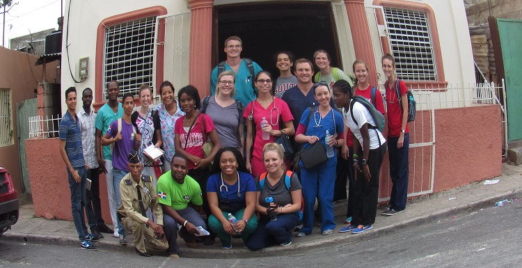 USA nursing students, Foundation for Peace staff and others gather outside a church used as a clinic site in the community of Los Mina.