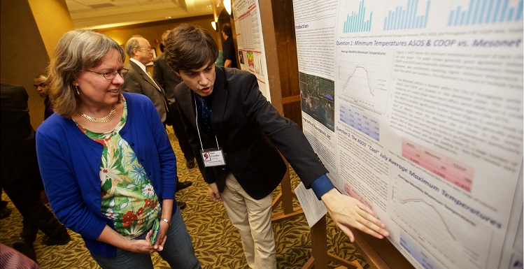 Dr. Sytske Kimball, left, chair of earth sciences, talks with senior meteorology student Nick Grondin about their research project during the 2016 SeCAPS meeting at South.