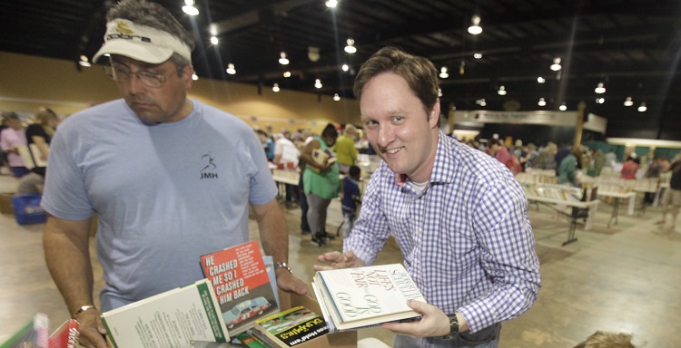 Joshua Cogswell, director of University development, tallies receipts for the Mobile Public Library?s book sale Saturday during the 2015 JaguarsCares National Day of Service.