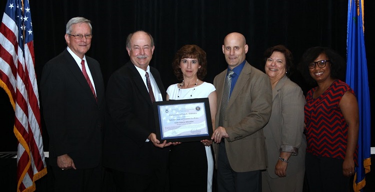 USA officials display the official certification for the School of Computing as a National Center of Academic Excellence during a recent conference in Las Vegas. From left are Dr. Leonard Reinsfelder, deputy director for education and training, National Security Agency; Dr. David Johnson, USA provost and senior vice president for academic affairs; Angela Clark, senior instructor of computing; Dr. Todd Andel, associate professor of computing; Lynne Clark, chief, National Information Assurance Education and Training Program, National Security Agency; and Jacqueline Sullivan, acting program lead, Department of Homeland Security National Cybersecurity Training and Education Program. 