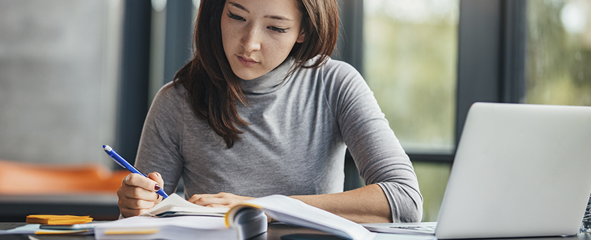 Female at desk writing on paper