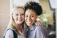 Two femal SGA members with arm around each other,