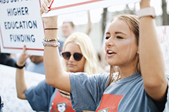 SGA students holding up signs for higher education funding.