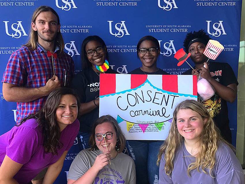 Several students posing with sign about consent