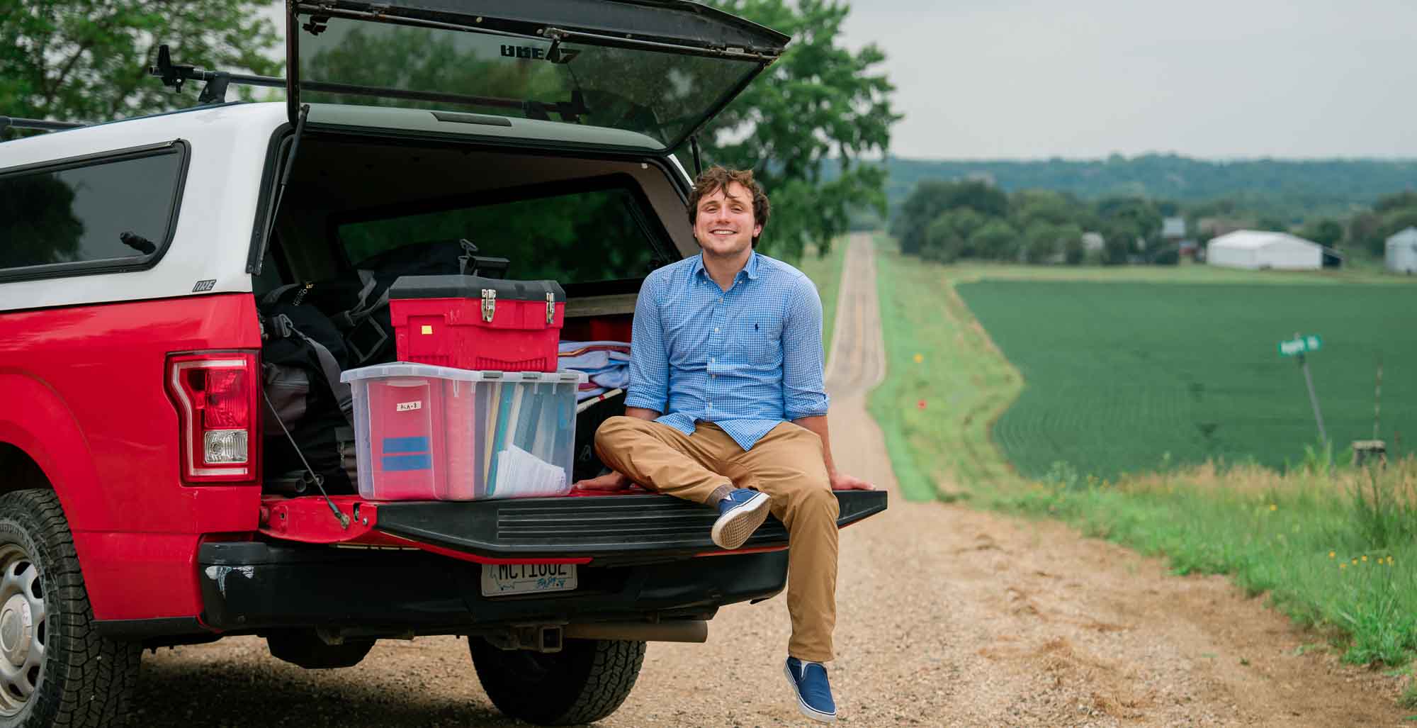 Ari sits in the back of a red truck data-lightbox='featured'