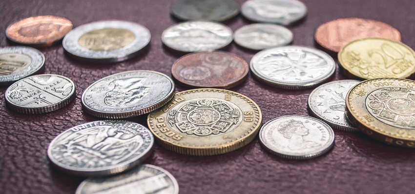 There are several coins laid out of different colors and sizes.