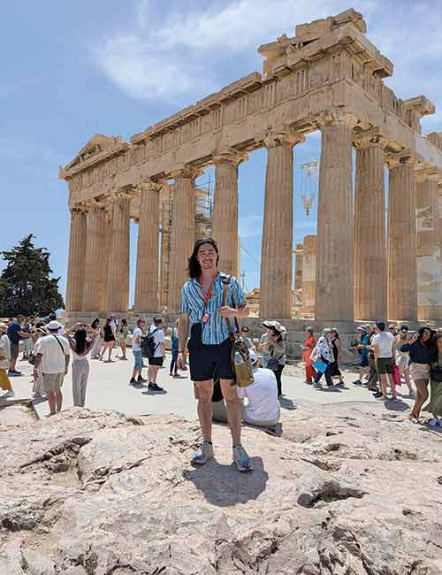 Jason Conrad poses in front of the Parthenon in Greece.