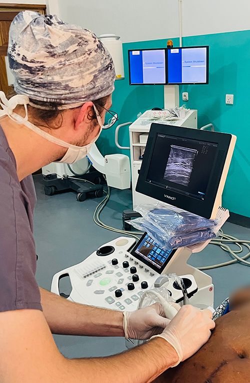 Chris Johnson uses needle localization on a patient at Kibogora Hospital.