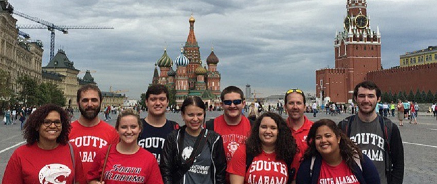 A group of students studying abroad standing in street in front of castle.