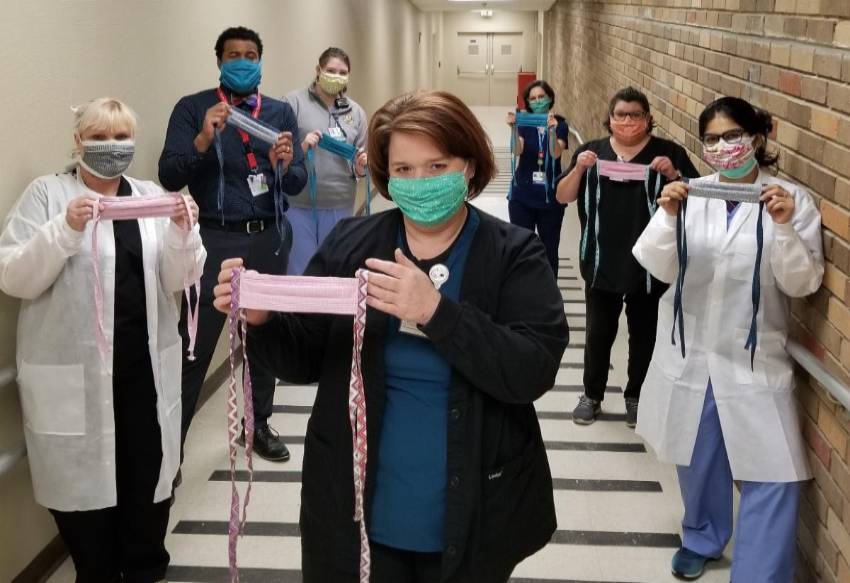 health care workers standing in hallway of hospital holding hand-made cloth masks