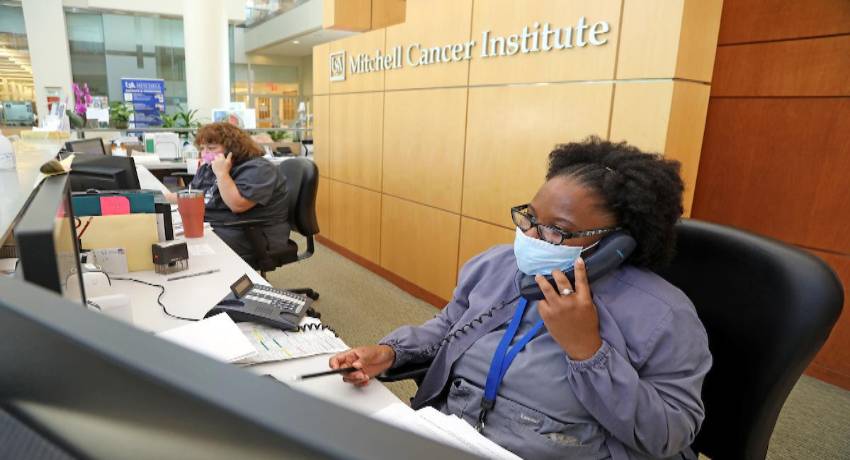health care workers on phones at front desk of Mitchell Cancer Center
