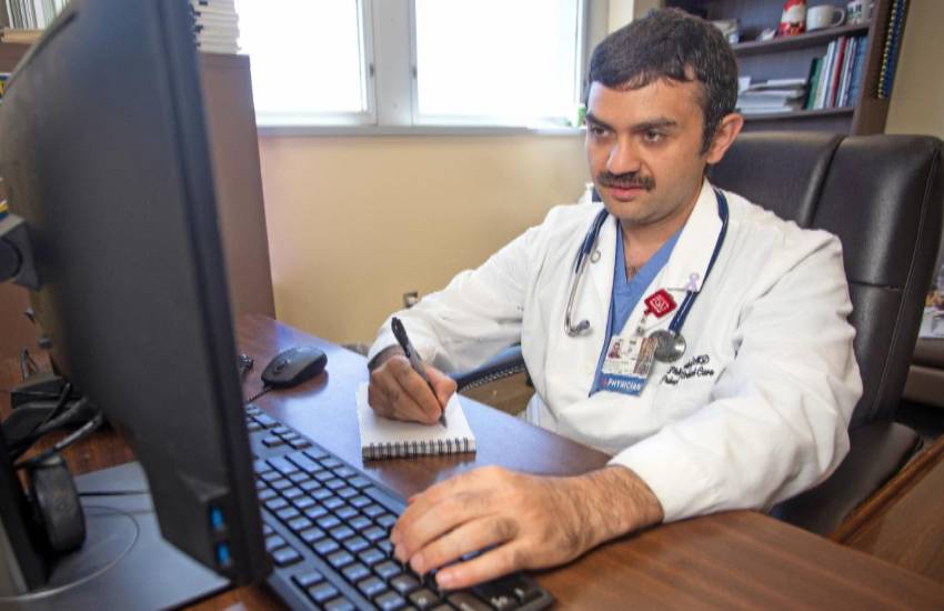 physician at computer on virtual visit with patient