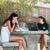 two students studying outside at picnic table under trees