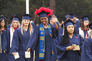 Students in cap and gowns walking to graduation.