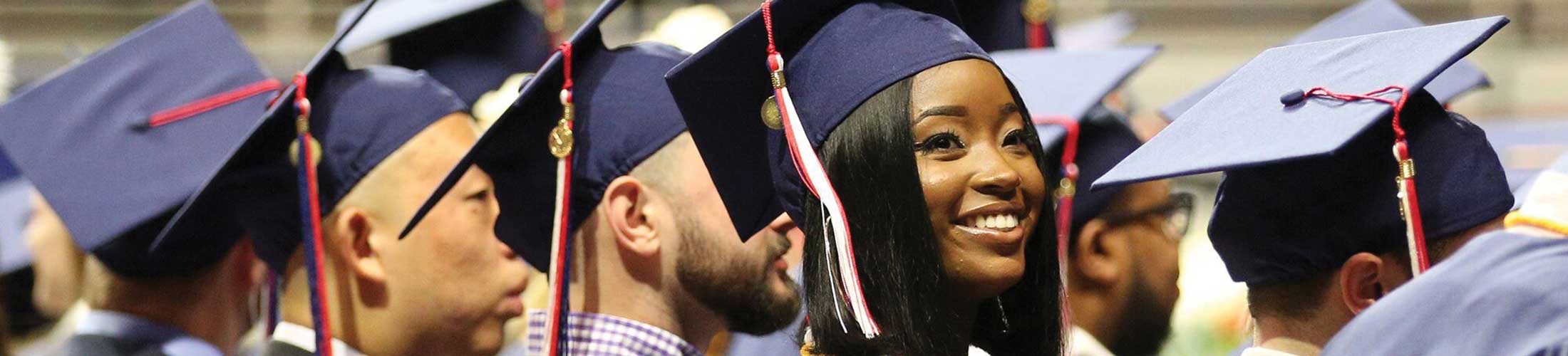 Students smiling in cap and gown.