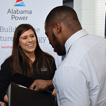Alabama Power set up at spring career fair with employee talking to student
