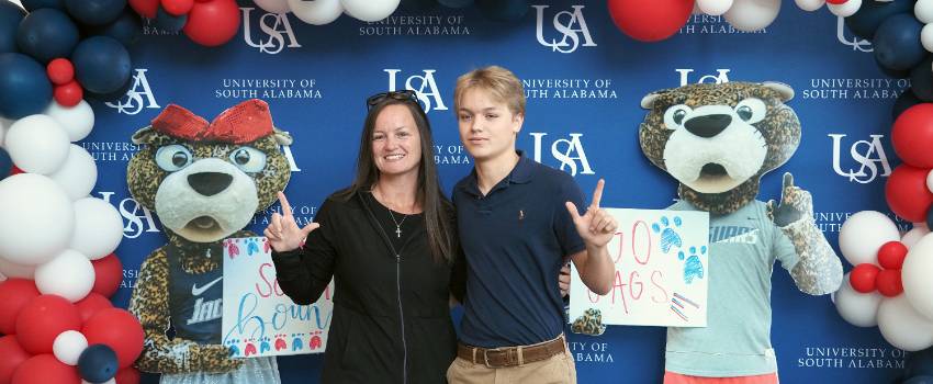 Parent and son with Southpaw and Ms. Pawla backdrop.